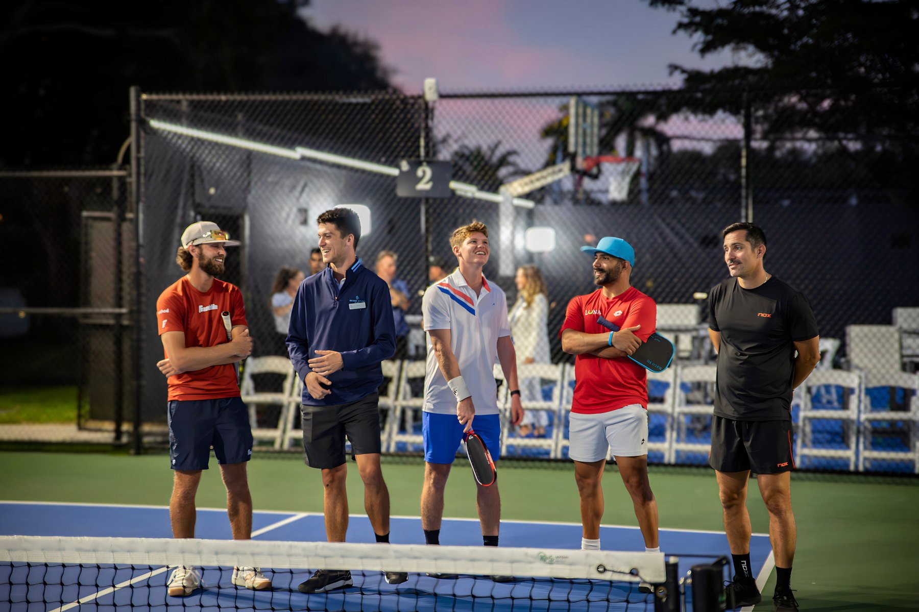 Frank Solana coaching a group on court at dusk